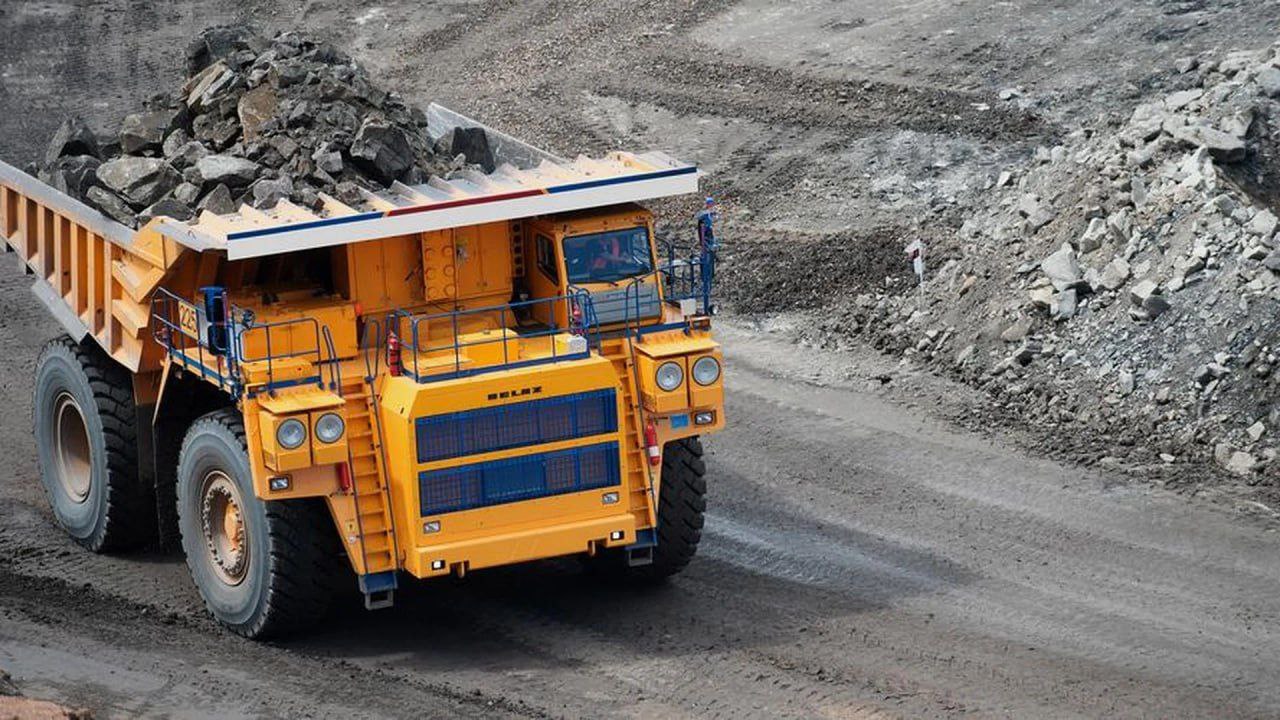 Карьерный самосвал BelAZ движется по технологической дороге открытого карьера